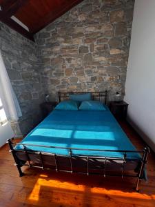 a bed in a room with a stone wall at Bordon wines, estate with accommodation in Dekani