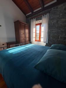 a bedroom with a large bed and a stone wall at Bordon wines, estate with accommodation in Dekani