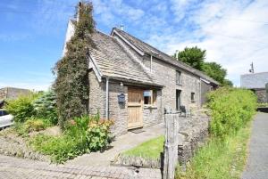an old stone house with a wooden door at The Barn in Crumlin