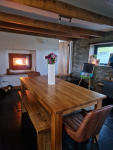 a wooden table with a vase of flowers on it at The Barn in Crumlin