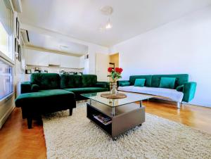 a living room with green couches and a coffee table at Chic and comfortable apart with Parking and Terrace in Asnières-sur-Seine