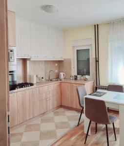 a kitchen with white cabinets and a table and chairs at Urban Retreat in Osijek