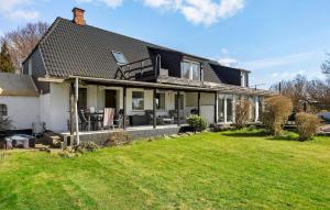 a black and white house with a yard at 2 Bedroom Nice Apartment In Sydals in Østerby