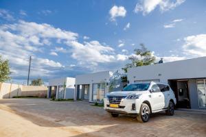 a white truck parked in front of a building at lush apartments in Lilongwe