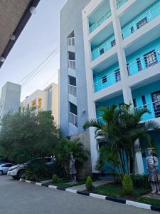 a building with palm trees in front of it at Nanic Homes Rio Vista in Marimbeti
