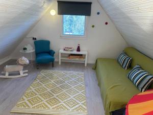 a room with a couch and a chair in a attic at Halacska Ház in Alsóörs