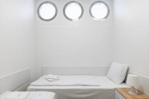 two mirrors above a bed in a white room at Sunset Waves - Right at the beach in Dziwnówek