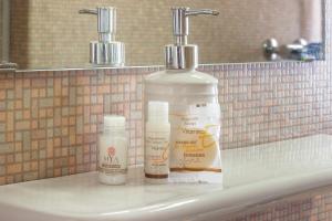 two bottles of moisturizers sitting on a bathroom sink at Essenzial Piazza Grande Locarno in Locarno +14 photos