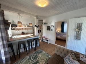 a living room with a kitchen and a bar with stools at Halacska Ház in Alsóörs