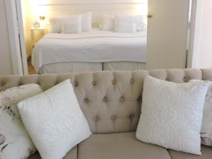 a white couch with pillows in front of a bed at AE Buenos Aires in Buenos Aires