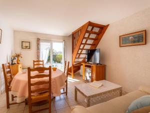 ein Wohnzimmer mit Tisch und Wendeltreppe in der Unterkunft Maison mitoyenne à Locmariaquer, 4 pièces, 47m², animaux acceptés - FR-1-477-252 in Locmariaquer