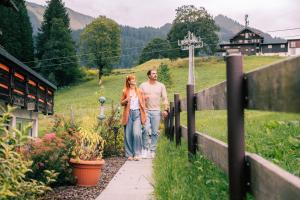 Un uomo e una donna che camminano lungo un marciapiede di Hotel Gemma- Adults only a Hirschegg