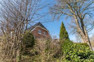 una casa di mattoni rossi in mezzo agli alberi di Ferienhaus von Osten a Burg