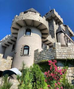 a building with a tower with flowers in front of it at Royal Valentina Castle in Ognyanovo