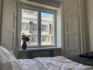 una camera con letto e finestra con vaso di fiori di Luxury 2BDR Apartment in Center with Free Parking a Helsinki