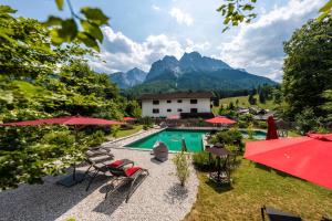 an outdoor swimming pool with mountains in the background at Bayern Resort Apartments in Grainau