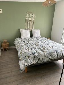 a bedroom with a large bed with a comforter at Appartement 29D à Mailly-le-Camp in Mailly-le-Camp