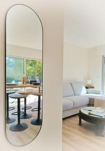 a mirror in a living room with a couch and a table at Renovated 2-room apartment near sea & shops in Théoule-sur-Mer