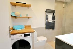 a bathroom with a washing machine and a toilet at Renovated 2-room apartment near sea & shops in Théoule-sur-Mer +14 photos
