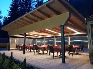 a group of tables and chairs under a pavilion at Hotel Villetta Maria Cottage in Canazei +74 photos