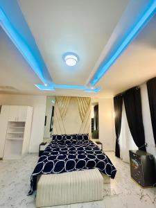 Un dormitorio con una cama con techo azul. en SweetHomeVilla, en Lekki