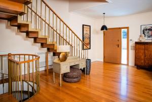 ein Wohnzimmer mit einer Treppe und einem Tisch in der Unterkunft South Blue Tranquil Villa in Athen