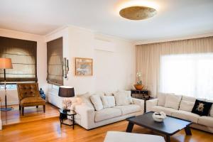 ein Wohnzimmer mit Sofa und Tisch in der Unterkunft South Blue Tranquil Villa in Athen