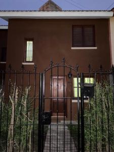 a gate in front of a house with a door at Casa de 3 dormitorios - Palpalá in Palpalá