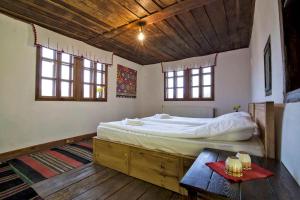 ein Schlafzimmer mit einem Bett und einem Tisch darin in der Unterkunft Incredible Cabin Getaway with Indoor and Outdoor Fireplaces in Selishte, Bulgaria in Karatsite