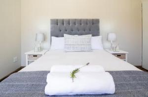 una camera da letto con un grande letto bianco con due tavoli di Miracle Villa a Kenton-on-Sea