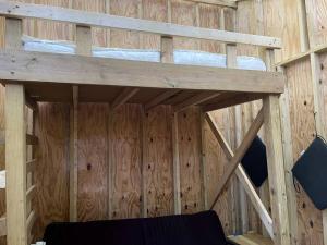 布恩Treehouse Glamping in Boone, NC的木墙内的一张木制双层床
