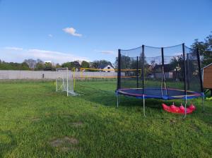 a playground with a trampoline in the grass at Noclegi nad stawami wypożyczalnia kajaków i rowerów in Milicz