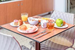 a table with breakfast foods and drinks on it at B&B Hotel Milano San Siro in Milan