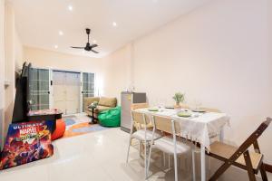 a dining room with a white table and chairs at OH Homes - Samsen 12 in Bangkok