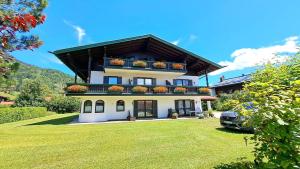 a large house with two balconies on top of a yard at Ferienwohnung Fleck in Reit im Winkl