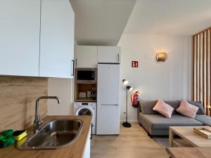 a kitchen and a living room with a couch at Rincon de Ensueño en Marquesado in Madrid