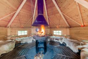 a large room with a fireplace in a wooden cabin at Trysil Hyttegrend in Trysil