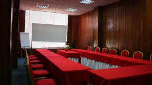a conference room with red tables and chairs and a screen at Hotel Inter Chimoio in Chimoio