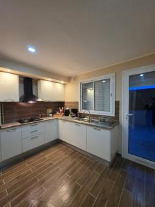 a kitchen with white cabinets and a large window at appartement Sarra Mahdia in Hiboun