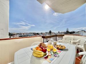 a table with a plate of fruit on a balcony at Albufeira Skylight 2 by Homing in Vale de Pedras