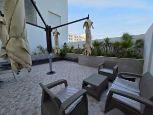 a patio with chairs and tables on a roof at appartement Sarra Mahdia in Hiboun