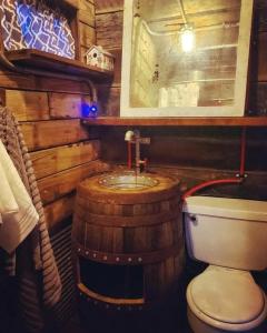 a bathroom with a toilet and a sink in a cabin at Rustic Container Accommodation for Glamping in Kentucky in Owenton