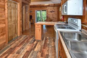 a kitchen with a stove and a sink in a cabin at Rustic Cabin with Jacuzzi Surrounded by Nature in Ohio in Rockbridge