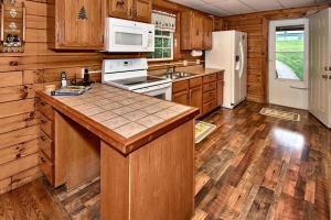 a kitchen with wooden cabinets and a white refrigerator at Rustic Cabin with Jacuzzi Surrounded by Nature in Ohio in Rockbridge +23 photos