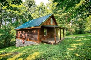 a small cabin with a porch in the grass at Rustic Cabin with Jacuzzi Surrounded by Nature in Ohio in Rockbridge