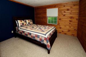 a bedroom with a bed and a window at Rustic Cabin with Jacuzzi Surrounded by Nature in Ohio in Rockbridge