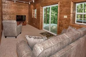 a living room with a couch and a chair at Rustic Cabin with Jacuzzi Surrounded by Nature in Ohio in Rockbridge