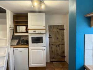 una cucina con elettrodomestici bianchi e porta in legno di Cosy Little Cottage a Woodbridge Altre 12 foto