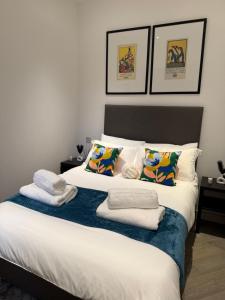 une chambre avec un lit avec des serviettes dessus dans l'établissement Cozy Luxury Apartment In The Heart Of Slough -The Bethel Suite, à Slough