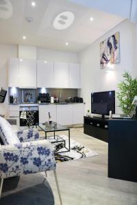 un salon avec un canapé et une table et une cuisine dans l'établissement Cozy Luxury Apartment In The Heart Of Slough -The Bethel Suite, à Slough